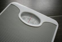 건강을 위한 동반자로서 다이어트와 운동 a bathroom scale sitting on top of a wooden table