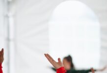 스트레칭으로 굳은몸을 풀어보 woman in red long sleeve shirt raising her hands