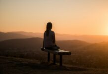 간단하지만 건강한 걷기운동 woman sitting on bench over viewing mountain