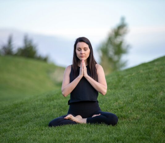 몸과 마음을 치유하는 요가와 명상 woman in black tank top and black pants sitting on green grass field during daytime