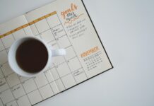 생산성 향상의 열쇠가 되는 직장 내 스트레스 관리 white ceramic mug with coffee on top of a planner