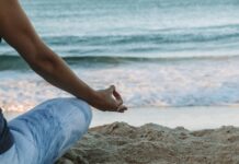 스트레스를 감소시키는 명상의 효과 person in blue shorts sitting on beach shore during daytime