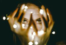 다크서클 예방법 woman holding string lights