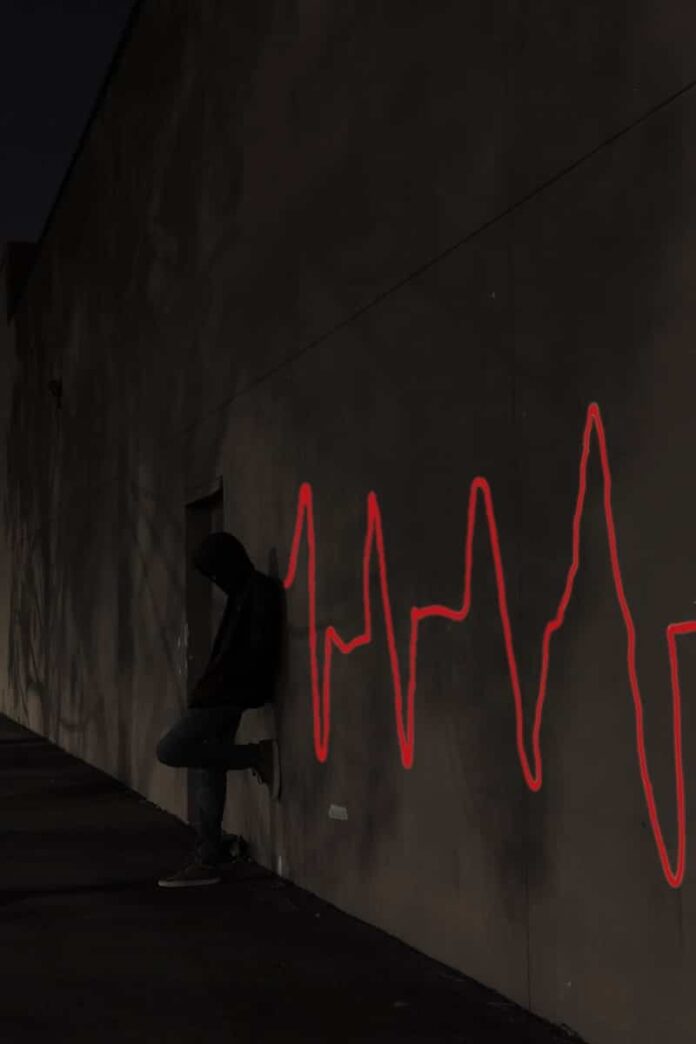 a man sitting on a skateboard in front of a wall