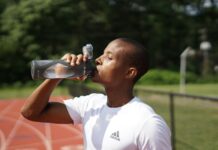 운동할 때 수분 섭취가 중요한 이유 man in white crew neck t-shirt drinking from black sports bottle