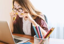 만성 스트레스와 코르티솔 수치: 건강에 미치는 장기적 영향 woman biting pencil while sitting on chair in front of computer during daytime