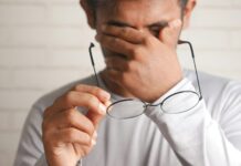 현대인의 눈 건강: 디지털 시대에 필요한 관리법 a man holding a pair of glasses up to his face
