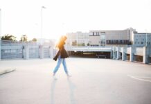 일상에서 쉽게 실천할 수 있는 피로 회복 방법 woman walking on road near building at daytime