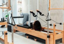 필라테스, 현대인 건강을 위한 맞춤 운동법으로 주목받다 a woman is doing exercises on a rowing machine