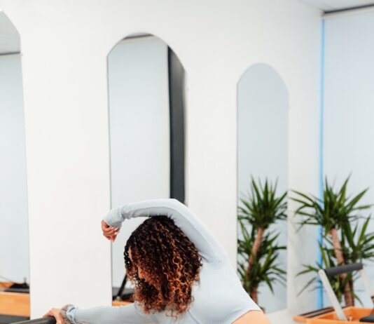 숨쉬기부터 자세까지, 일상에 활력을 더하는 필라테스의 매력 a woman is doing exercises on a rowing machine